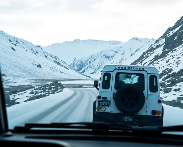 Land Rover Defender Driving Through Snowy Mountain Pass