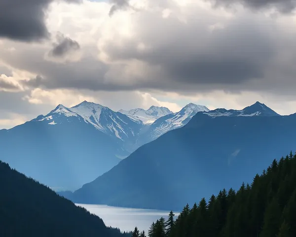 Majestic Mountain Range with Snow-Capped Peaks and Serene Lake Background