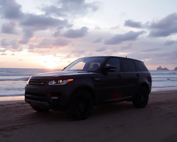Range Rover on Beach with Sunset Over Ocean