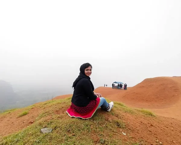 Sad Punjabi Woman on Hillside with Faint City View