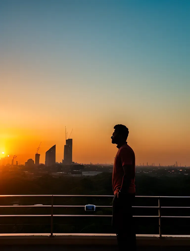 Jayasurya Silhouetted Against City Sunset Glory